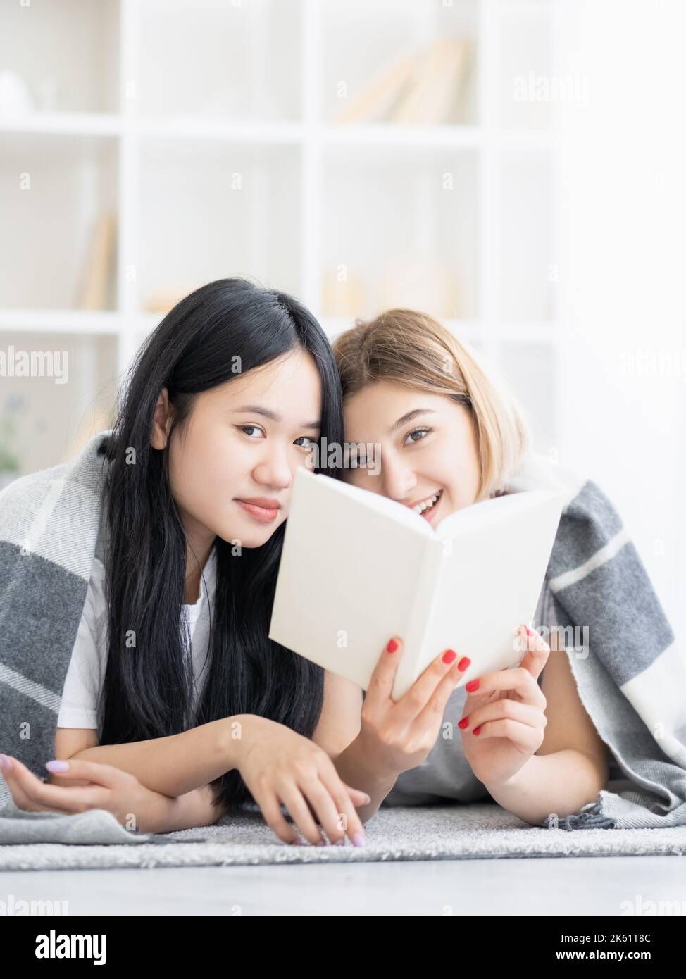 amichevole riunione felice femmina amici a casa lettura Foto Stock