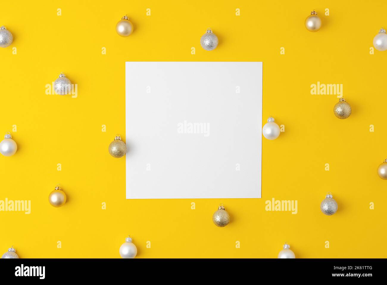 Sfondo giallo di Natale minimo con mock su biglietti di auguri e palla. Giacitura piatta, spazio di copia Foto Stock
