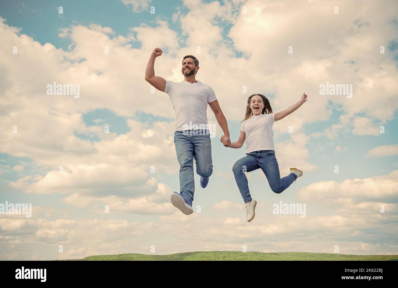 felice padre e figlia saltano in cielo. sostegno della famiglia Foto Stock