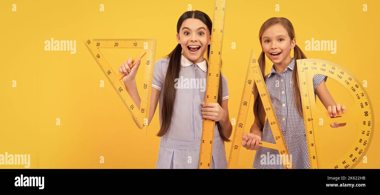 Scuole ragazze amici. È arrivato il ritorno a scuola. Le ragazze felici tengono gli attrezzi geometrici. Torna a scuola. Lezione di geometria. Banner della studentessa scolastica Foto Stock