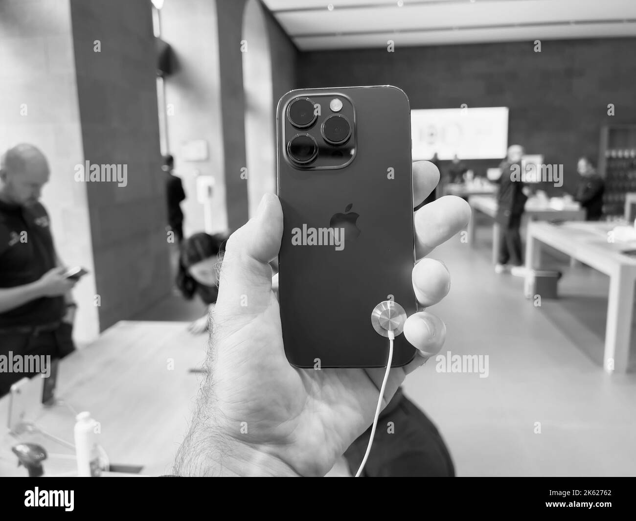 Parigi, Francia - 16 settembre 2022: Mano POV maschio che tiene il nuovo color viola Apple Computers iPhone 14 Pro durante il giorno del lancio con display always-on, fotocamera principale da 48 megapixel e Dynamic Island - negozio clienti in background Foto Stock