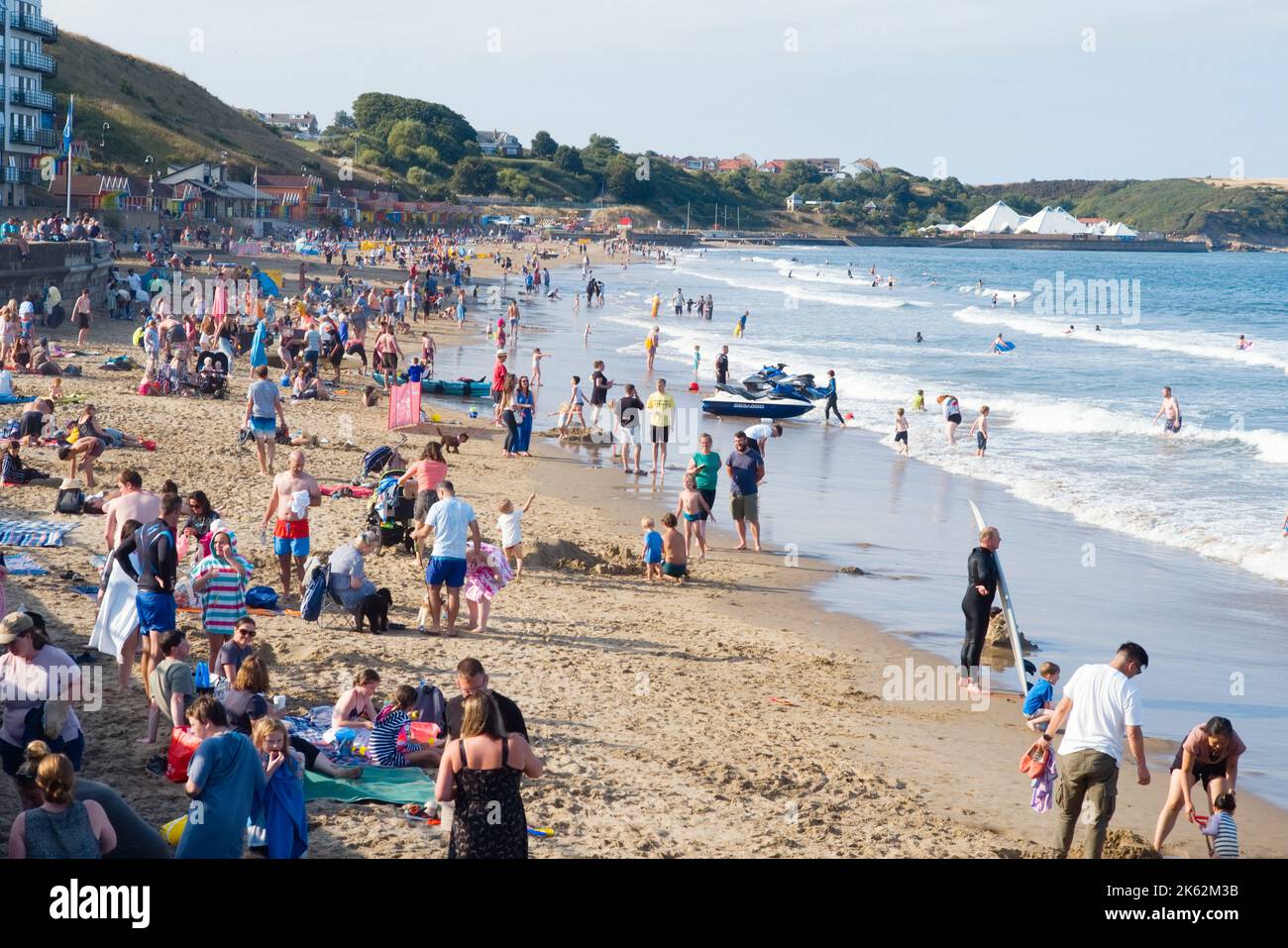 Guardando lungo la spiaggia di Scarborough's North Bay in un affollato weekend di vacanza in estate Foto Stock