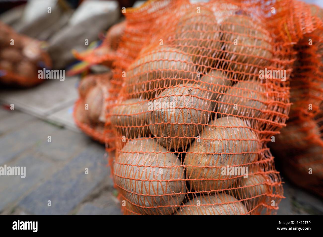 Profondità di campo poco profonda (focalizzazione selettiva) dettagli con patate in un sacco netto in un mercato agricolo europeo. Foto Stock
