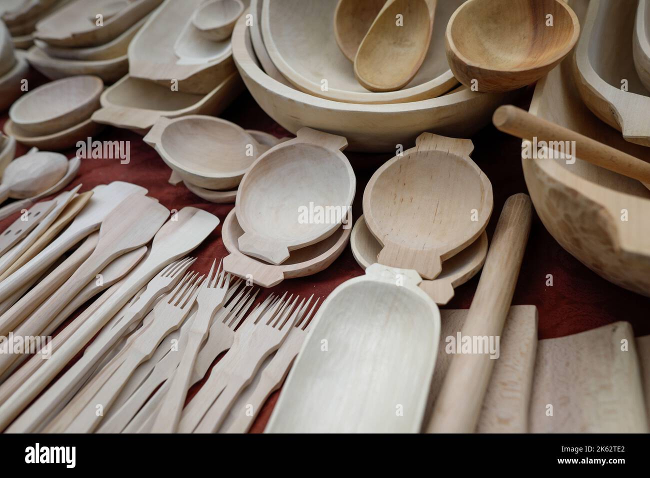 Profondità di campo bassa (fuoco selettivo) dettagli con rumeno tradizionale mano utensili da cucina in legno (ciotole, spatole, forchette, cucchiai). Foto Stock