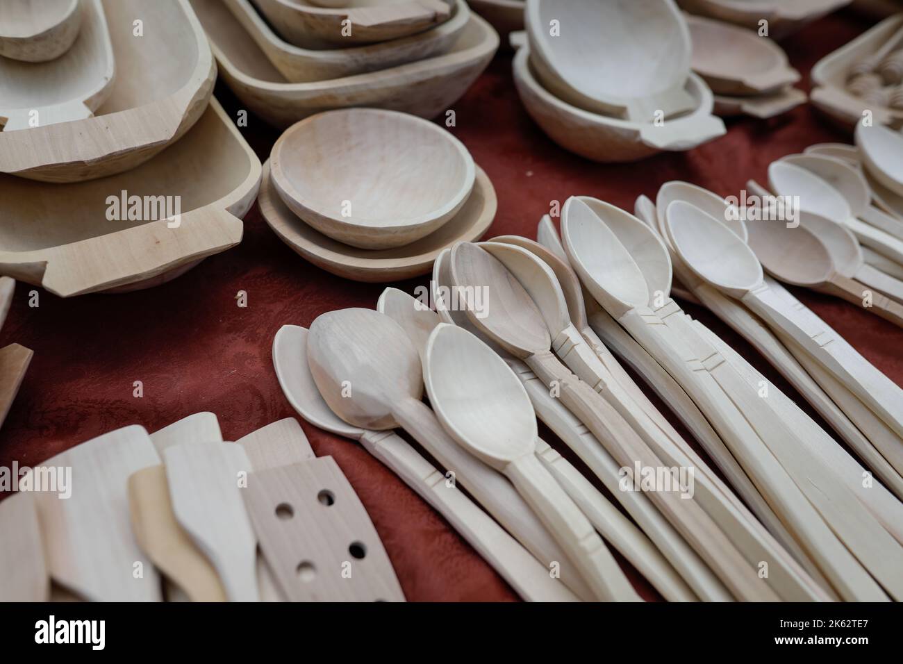 Profondità di campo bassa (fuoco selettivo) dettagli con rumeno tradizionale mano utensili da cucina in legno (ciotole, spatole, forchette, cucchiai). Foto Stock