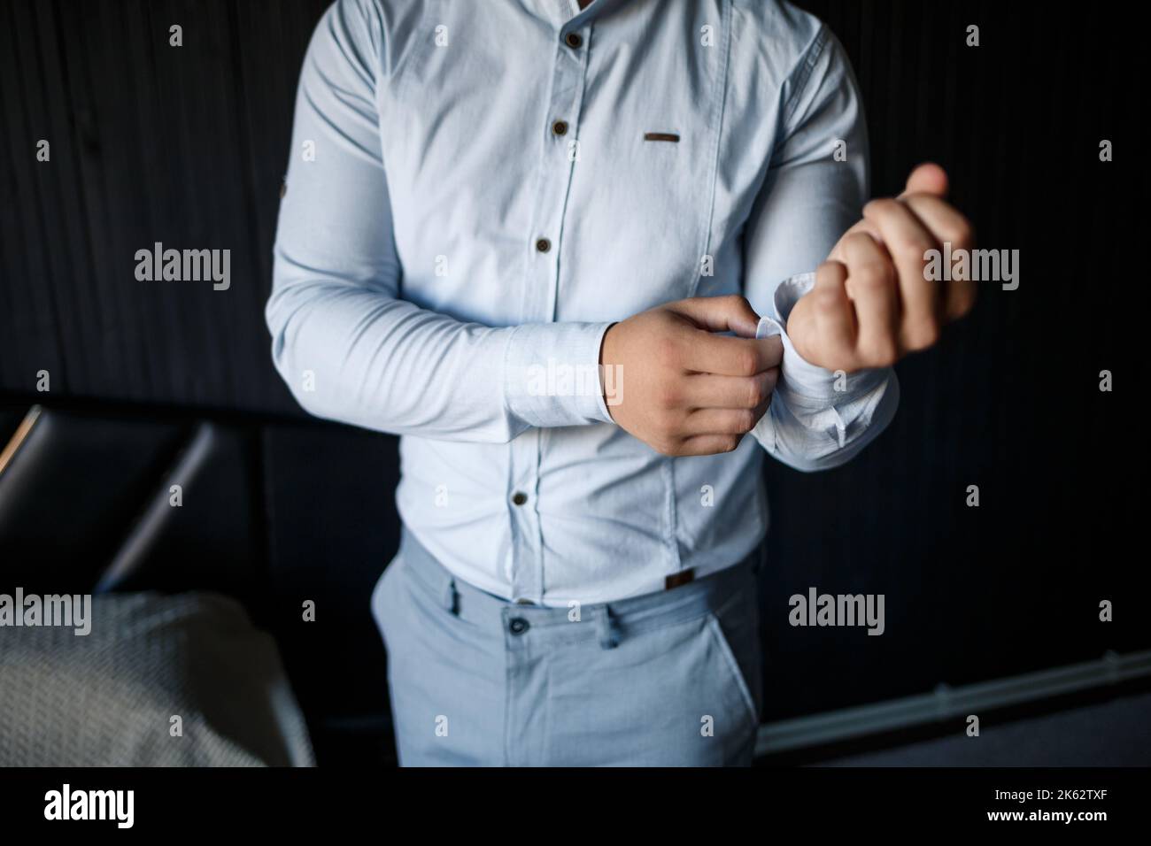 Uomo uomo d'affari che buttoning un pulsante sulla manica di un camicia bianca Foto Stock