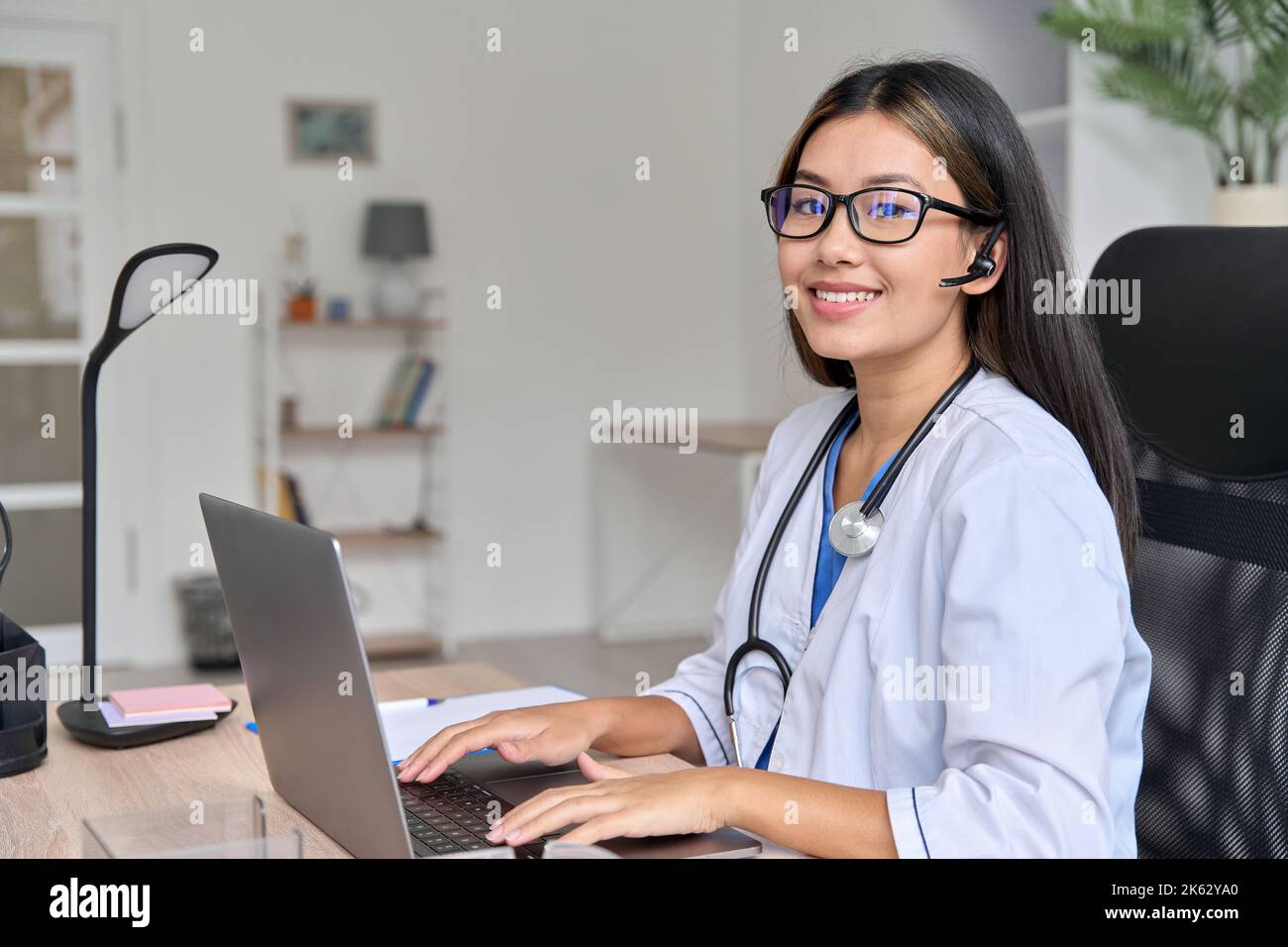 Ritratto di successo asiatico giovane dottoressa sul posto di lavoro moderno con notebook Foto Stock