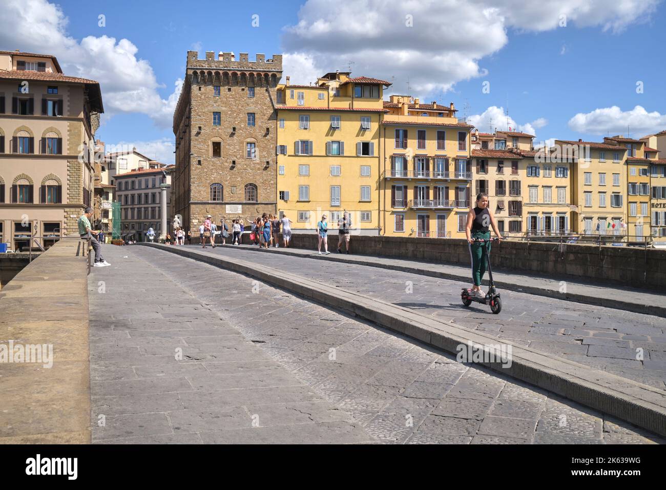 Ragazza su Escooter che attraversa Ponte Santa Trinita a Firenze Foto Stock