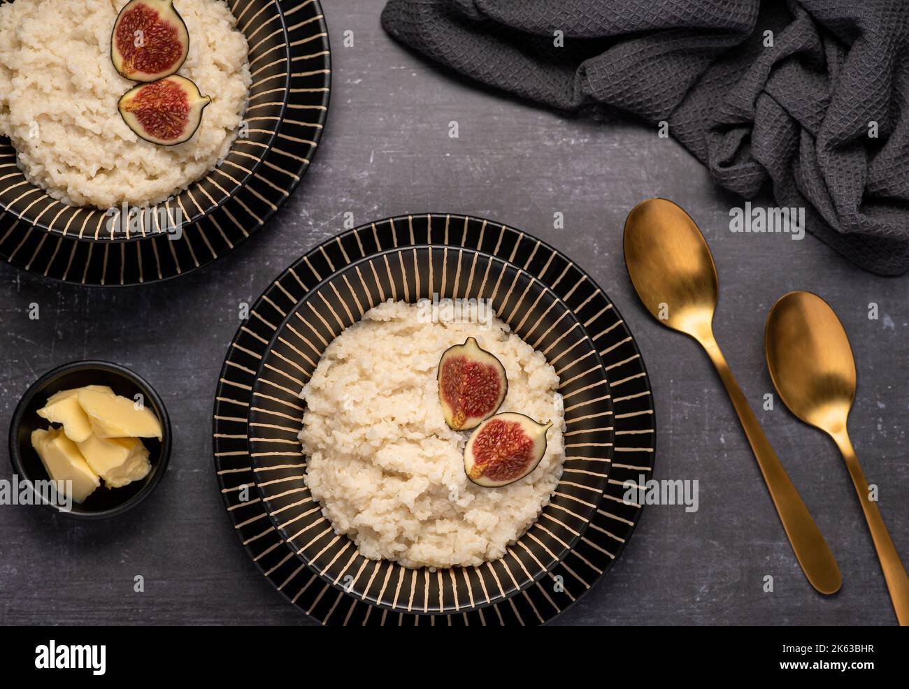 Fotografia macro-alimentare di porridge di riso, budino, cereali, fichi, cannella, burro Foto Stock