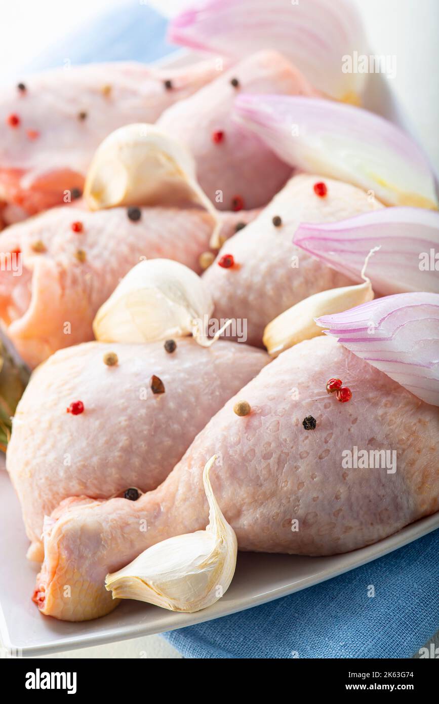 Cosce di pollo crude con verdure da cucinare sul tavolo da cucina Foto Stock