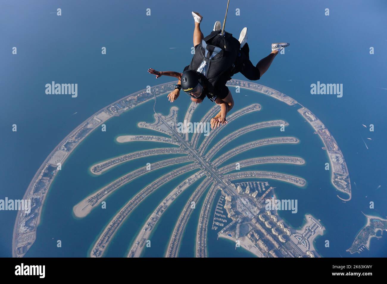 I paracadutisti tandem sorvolano Palm Jumeirah, una famosa isola artificiale, una delle principali attrazioni e punti di riferimento nella moderna città di Dubai, negli Emirati Arabi Uniti. Foto Stock