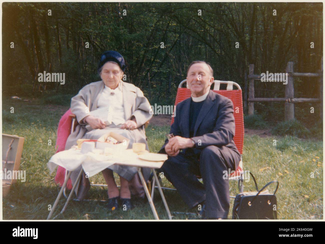 Il Vicario e uno dei suoi anziani parrocchiani condividere un po 'di tè e conversazione in un pic-nic estivo all'aperto in un campo di campagna - Giugno, 1965 Foto Stock