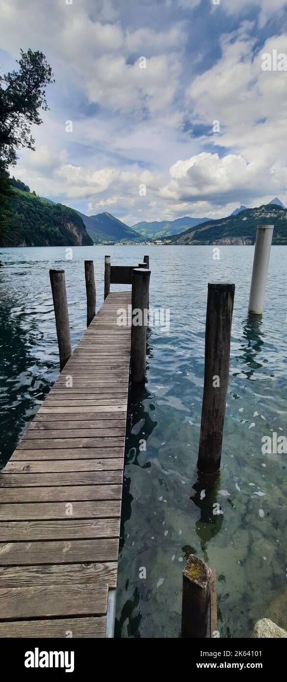 Un'immagine verticale di un molo in legno sulla riva del lago di Gelmer nelle Alpi svizzere, Gelmersee, Svizzera Foto Stock