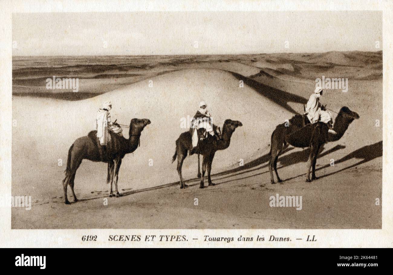 Tuaregs nomade in sella a cammelli tra le dune sahariane - Nord Africa. Data: Circa 1908 Foto Stock