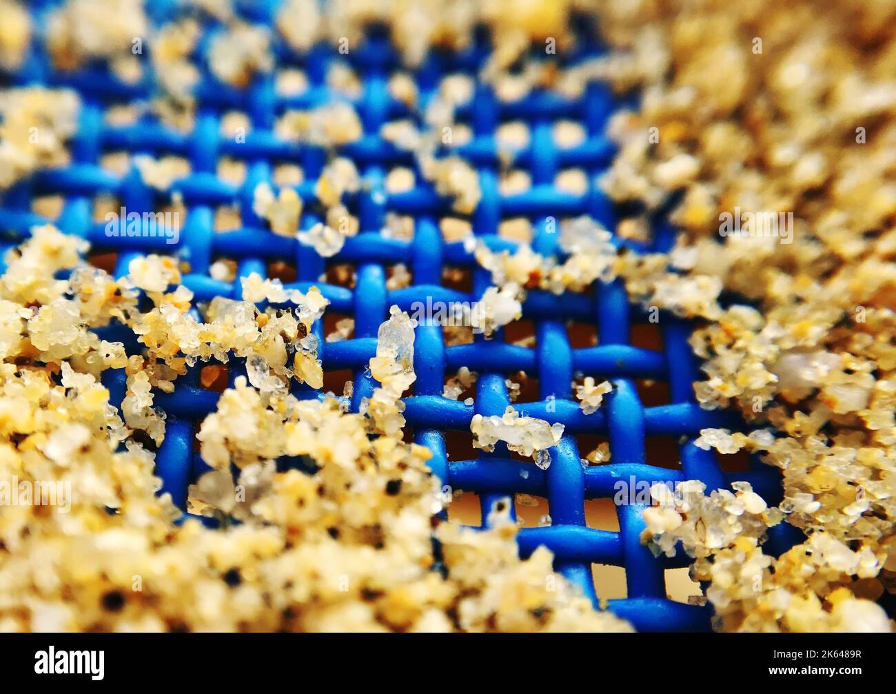 Un macrofone di sabbia su un lettino blu Foto Stock