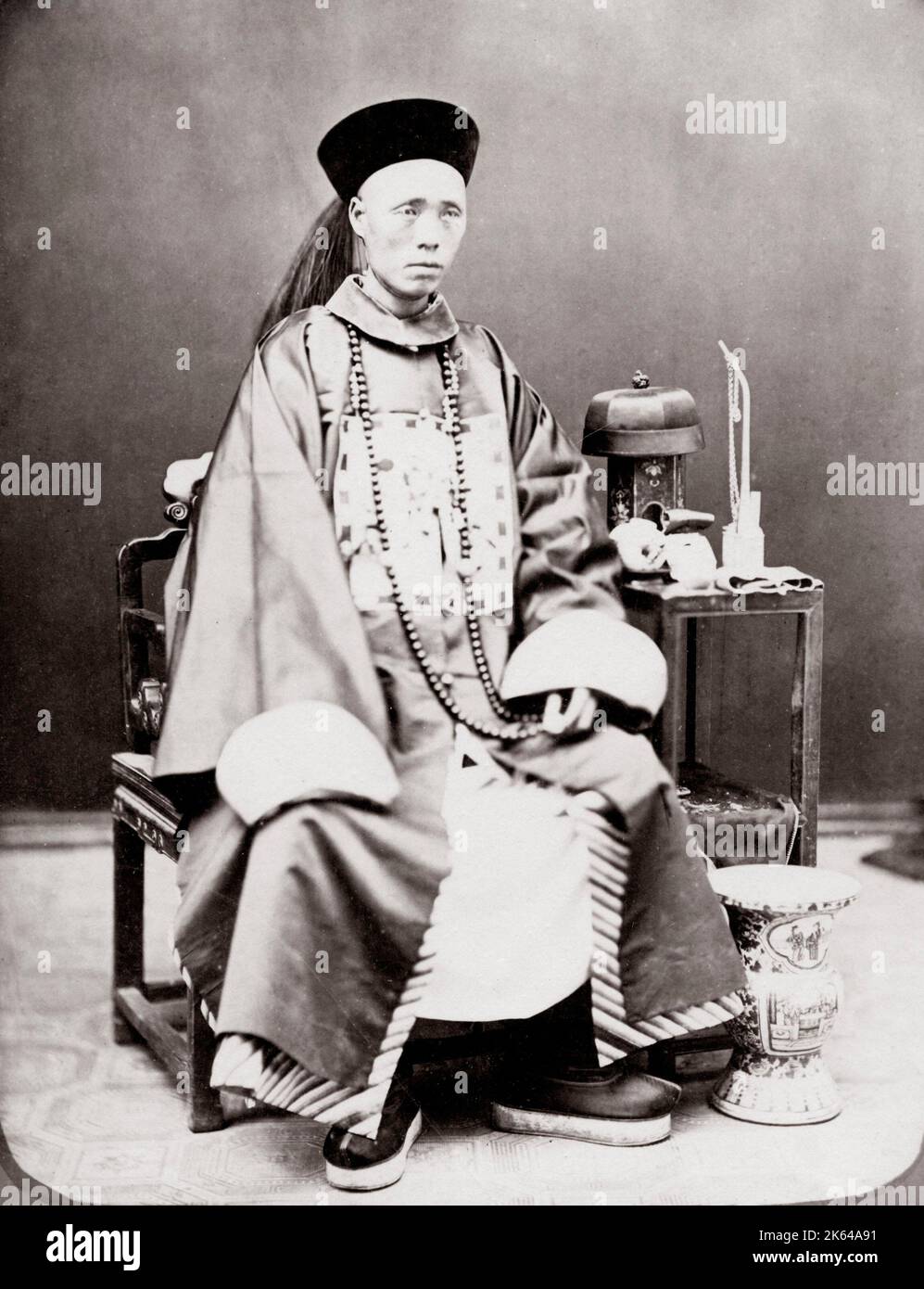 C.1880s Cina - facoltoso mercante Cinese o un mandarino, con elaborati accappatoi Foto Stock