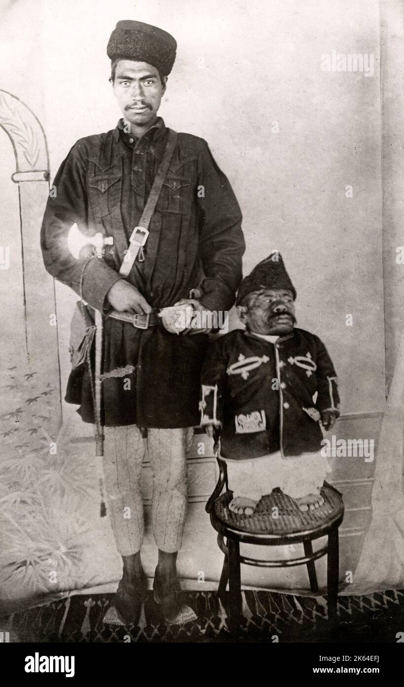 Fotografia da stampa vintage dei primi anni del 20th° secolo - nano afghano e gigante umano, c.1920 Foto Stock