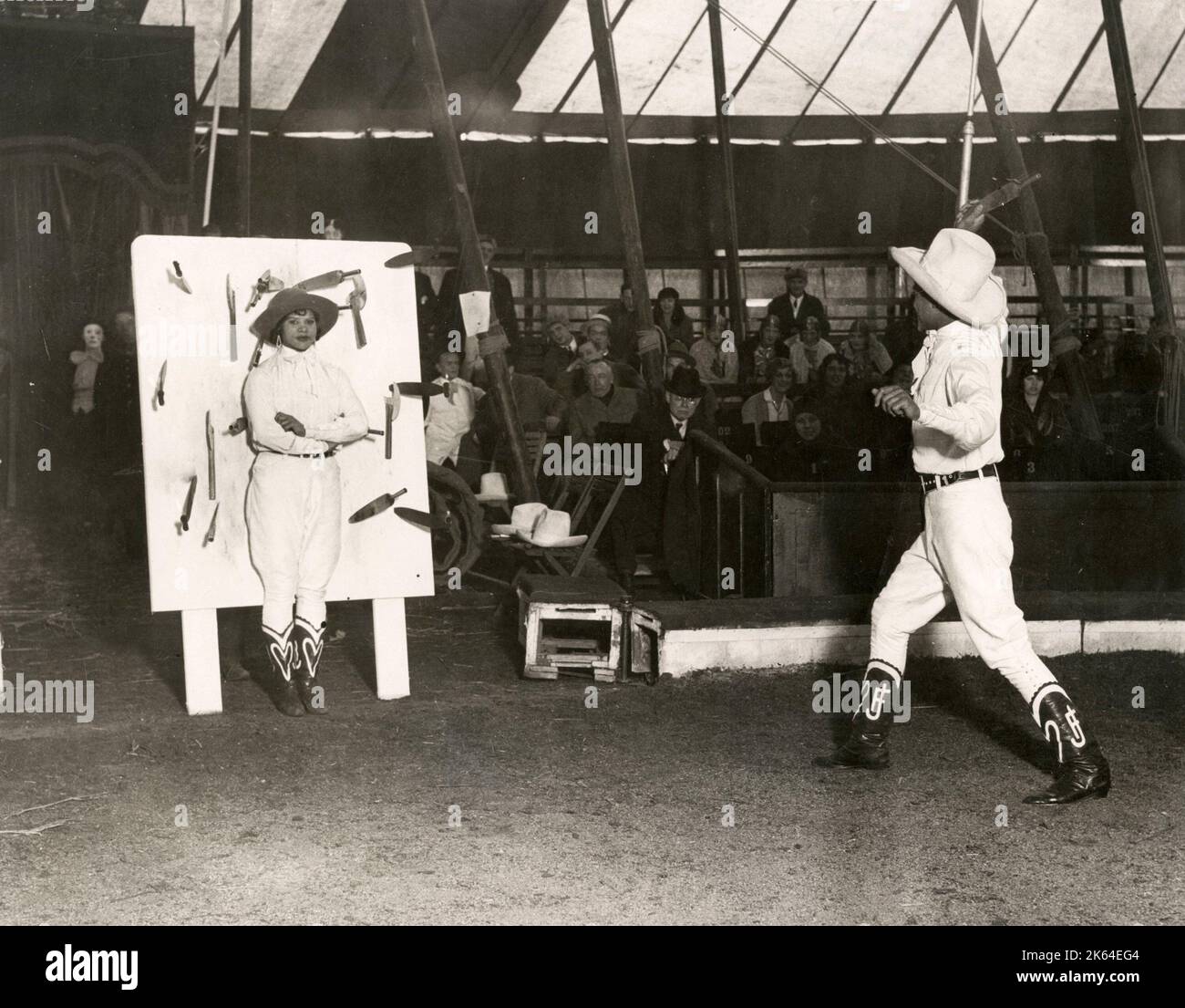 Nei primi anni del XX secolo vintage premere fotografia - coltello fiammeggiante gettando agiscono sotto la grande cima, Bertram Mills circus in tour a Luton Inghilterra, c.1920s. Foto Stock