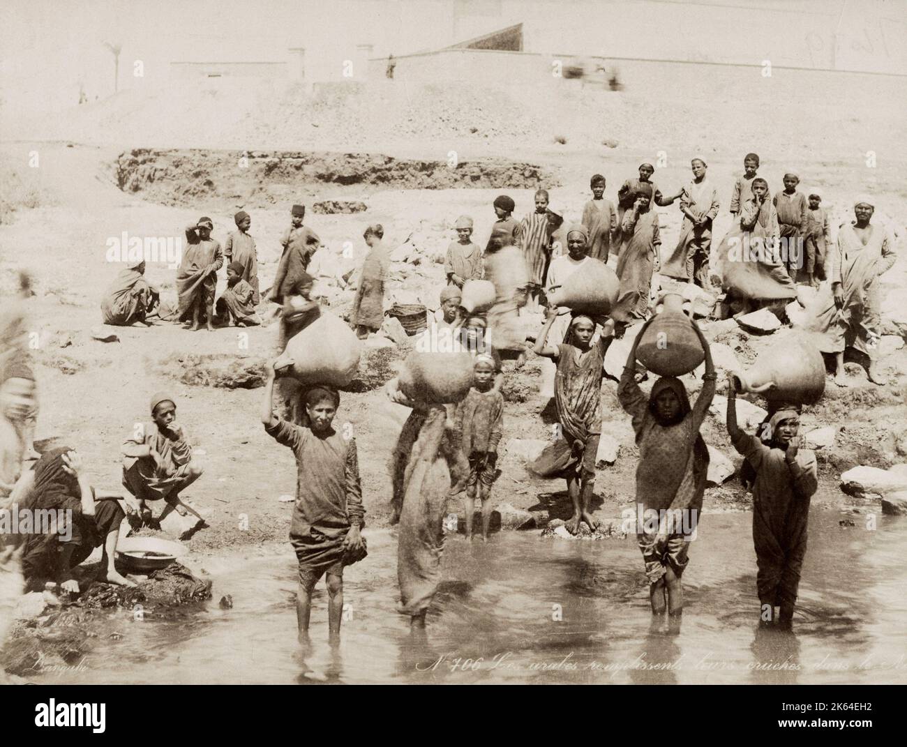 19 ° secolo vintage fotografia: Le donne che riempiono le loro pentole d'acqua dal fiume Nilo, Egitto, circa 1890. Monolocale Zangaki. Foto Stock