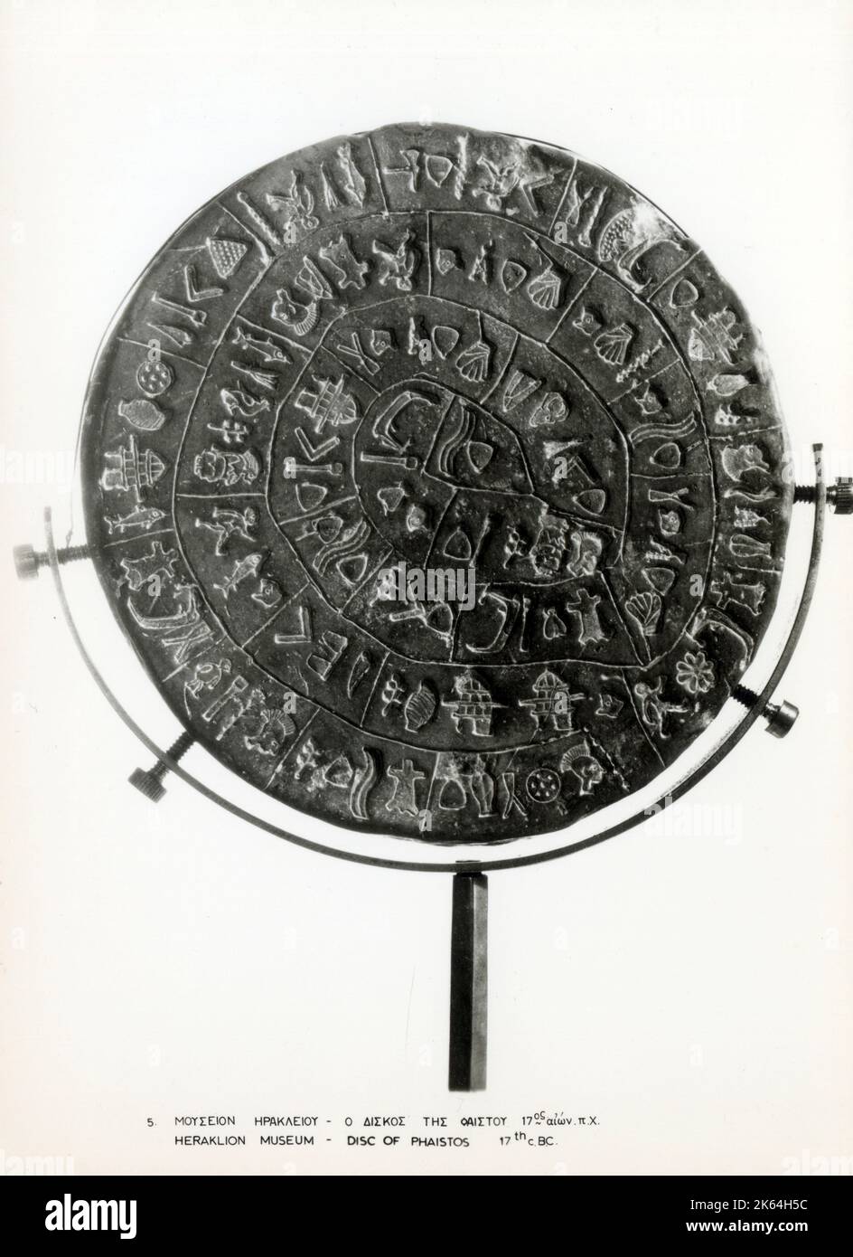 Il disco di Phaistos (anche scritto disco di Phaistos, disco di Phaestos) è un disco di argilla cotta proveniente dal palazzo minoico di Phaistos sull'isola di Creta, forse risalente alla metà o alla fine dell'età del bronzo minoica (secondo millennio a.C.). Il disco ha un diametro di circa 15 cm (5,9 poll.) e è coperto su entrambi i lati da una spirale di simboli stampati. Il disco di Phaistos è stato scoperto nel palazzo minoico di Phaistos, vicino a Hagia Triada, sulla costa meridionale di Creta. Data: Circa 2500 a.C. Foto Stock