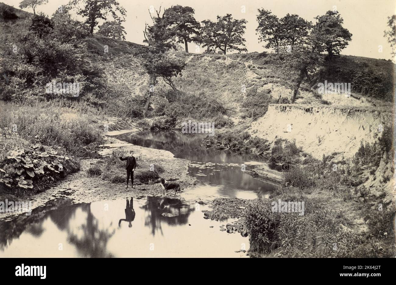 Famiglia Woolfe dei Clough, Hale, Bucklow, Cheshire - ragazzo e cane vicino al fiume Bollin Foto Stock