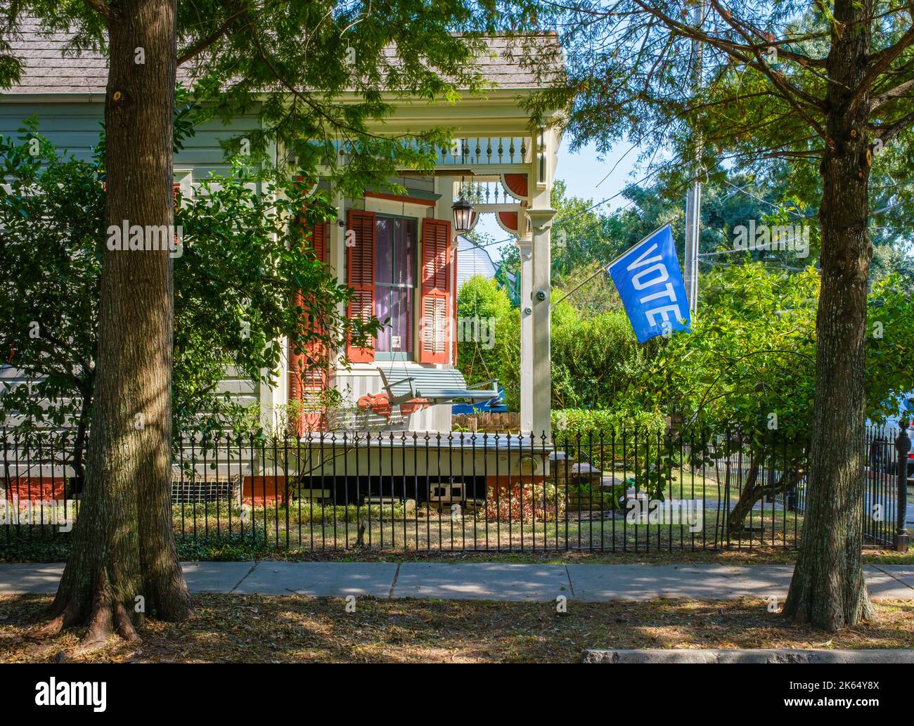 NEW ORLEANS, LA, Stati Uniti d'America - 7 OTTOBRE 2022: Storico Queen Anne Cottage con elaborato mulino e portico laterale incassato con altalena e bandiera di voto Foto Stock