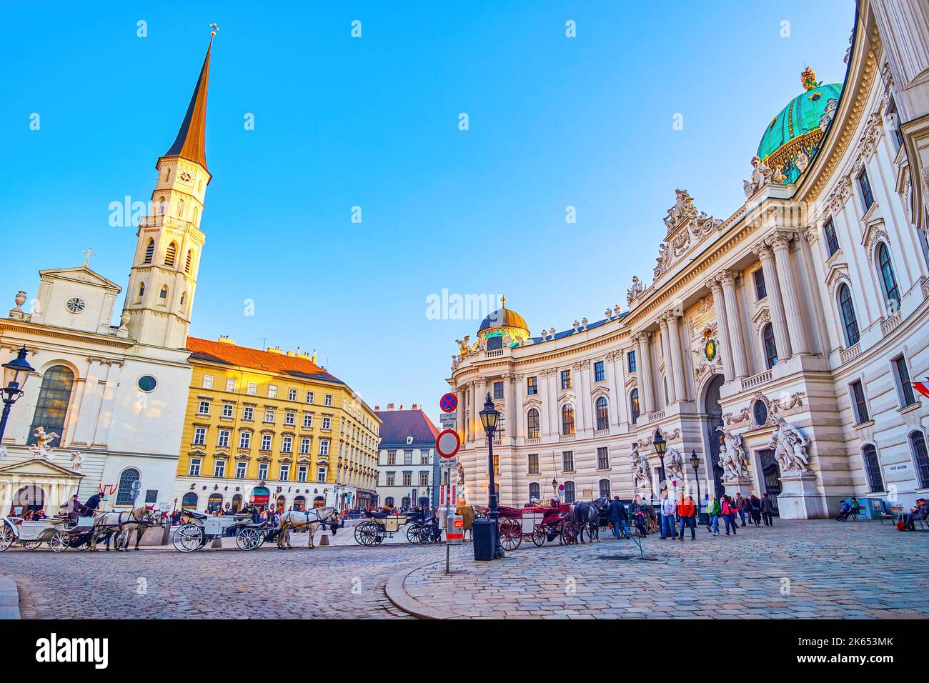 VIENNA, AUSTRIA - 17 FEBBRAIO 2019: Serata su Michaelerplatz con linee di carrozze turistiche trainate da cavalli al Palazzo Hofburg, il 17 febbraio a Vienna Foto Stock