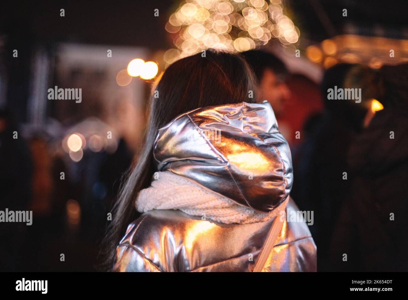 Vista posteriore della donna in piedi in città durante Natale di notte Foto Stock