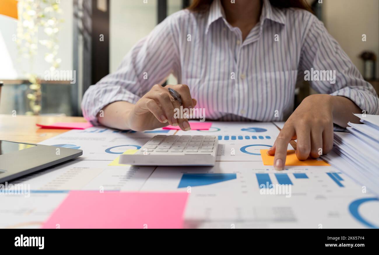 Financial Businesswomen analizza il grafico delle prestazioni dell'azienda per creare profitti e crescita, le relazioni di ricerche di mercato e le statistiche sul reddito Foto Stock