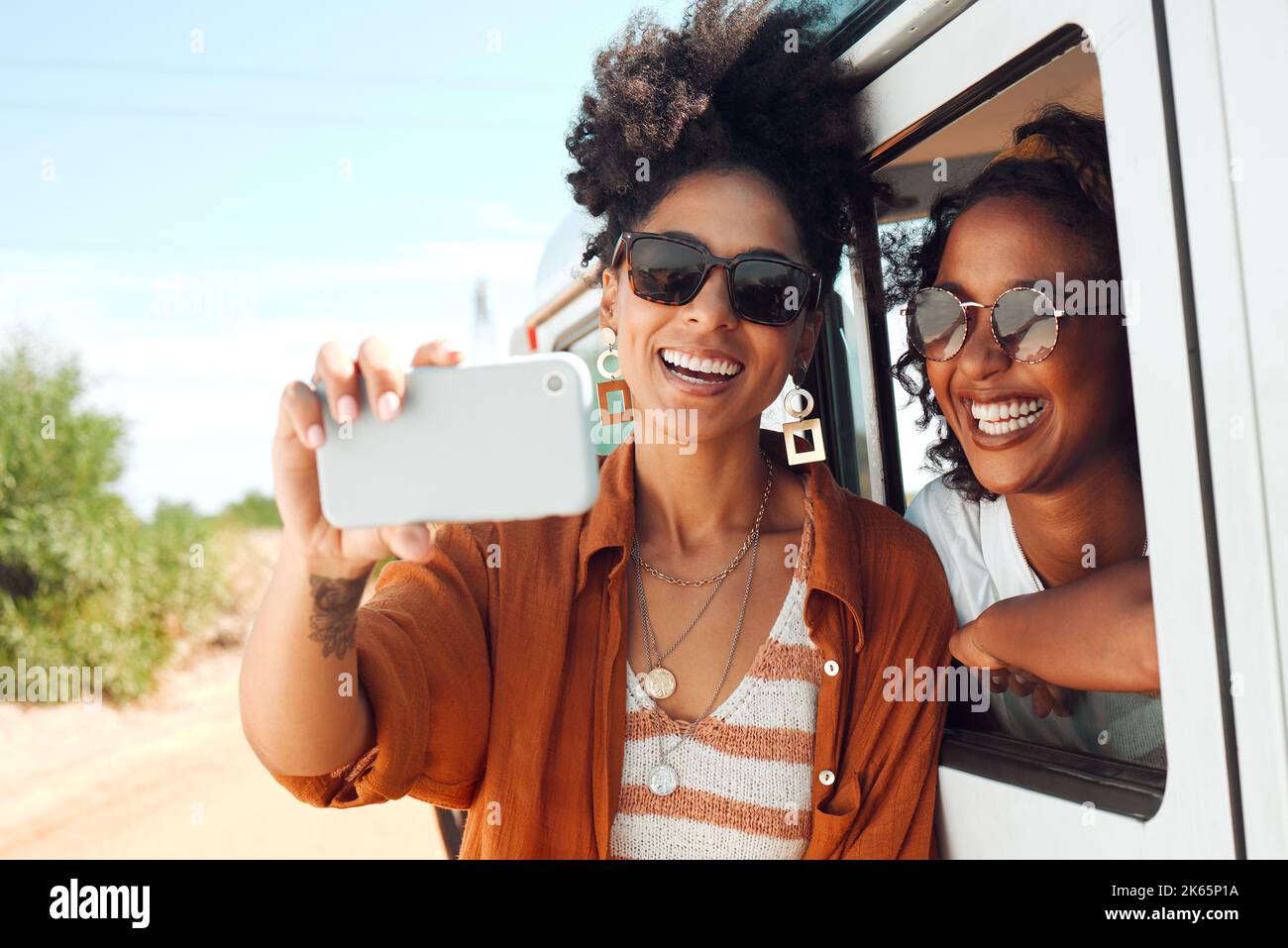 Selfie, sorriso e amici in un viaggio in auto durante una vacanza safari in Kenya. Donne africane con telefono per foto, comunicazione e sociale Foto Stock