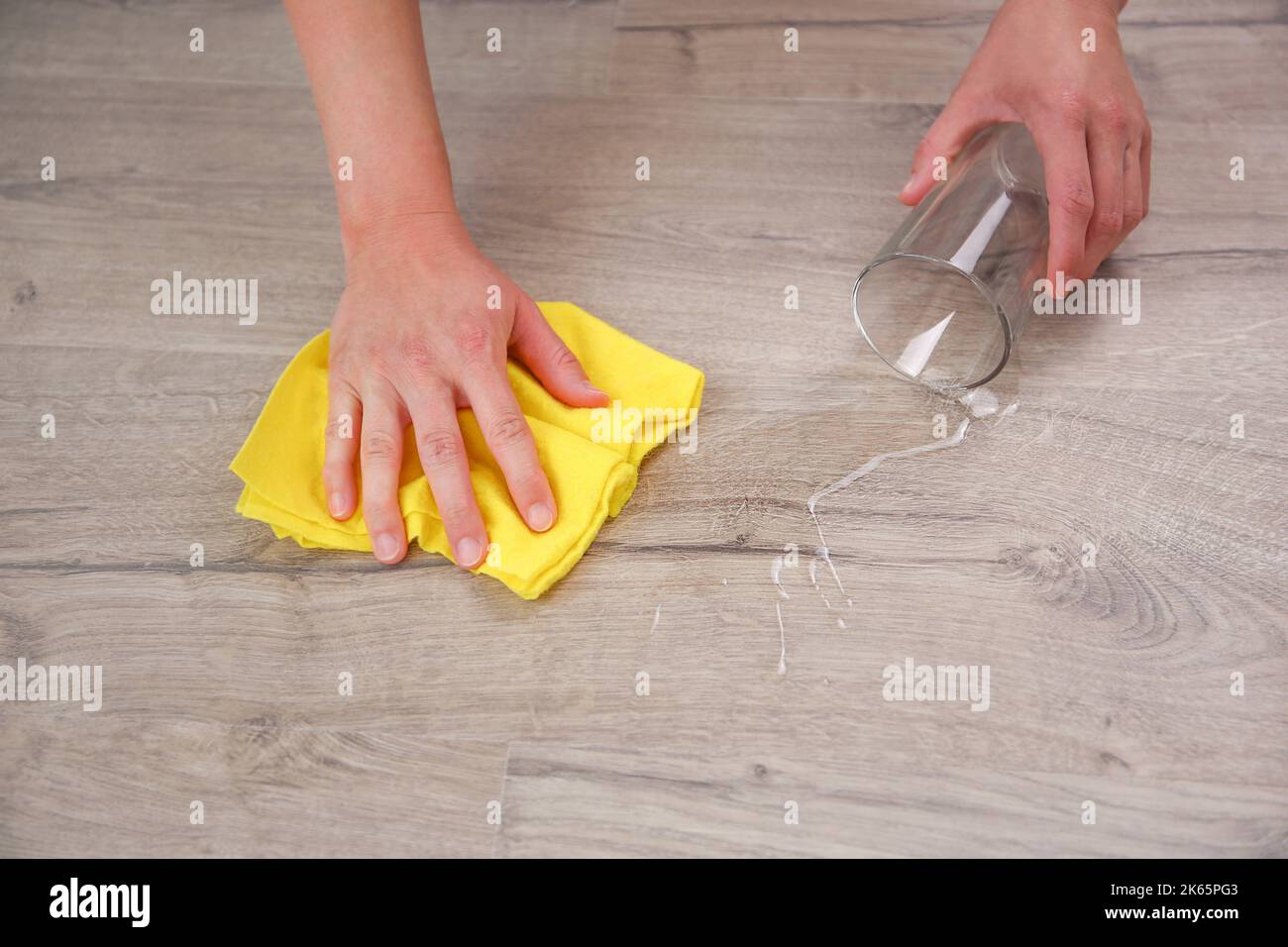 Vetro di acqua caduto su laminato, acqua versato sul pavimento. Foto Stock