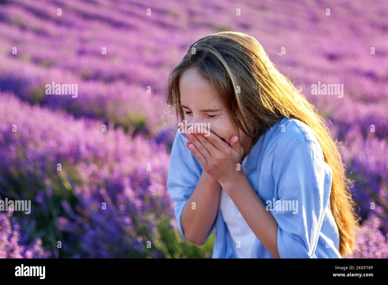 La ragazza starnutisce. Allergico ai fiori di lavanda. Foto Stock