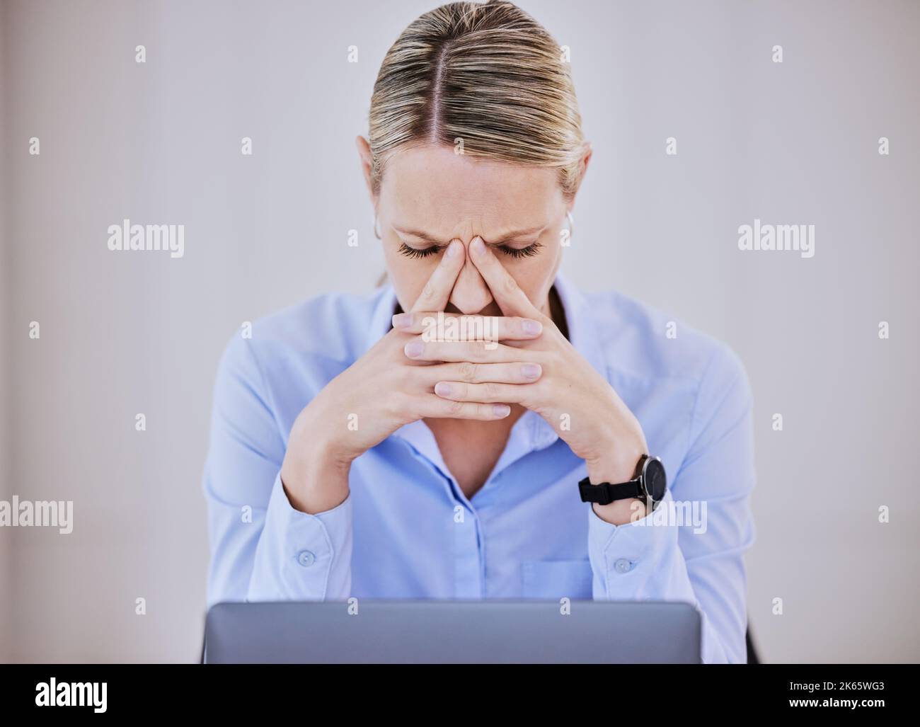 Giovane donna d'affari caucasica frustrato che lavora alla scrivania dell'ufficio che soffre di mal di testa cronico mentre si siede di fronte al laptop. Femmina Foto Stock