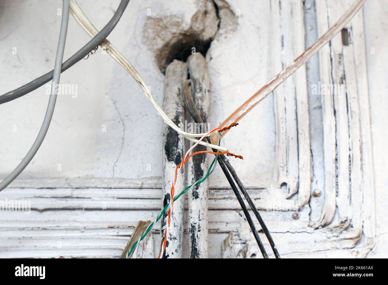 Cablaggio elettrico di pericolo. Filo esposto nel cablaggio elettrico nella parete. Messa a fuoco selettiva Foto Stock