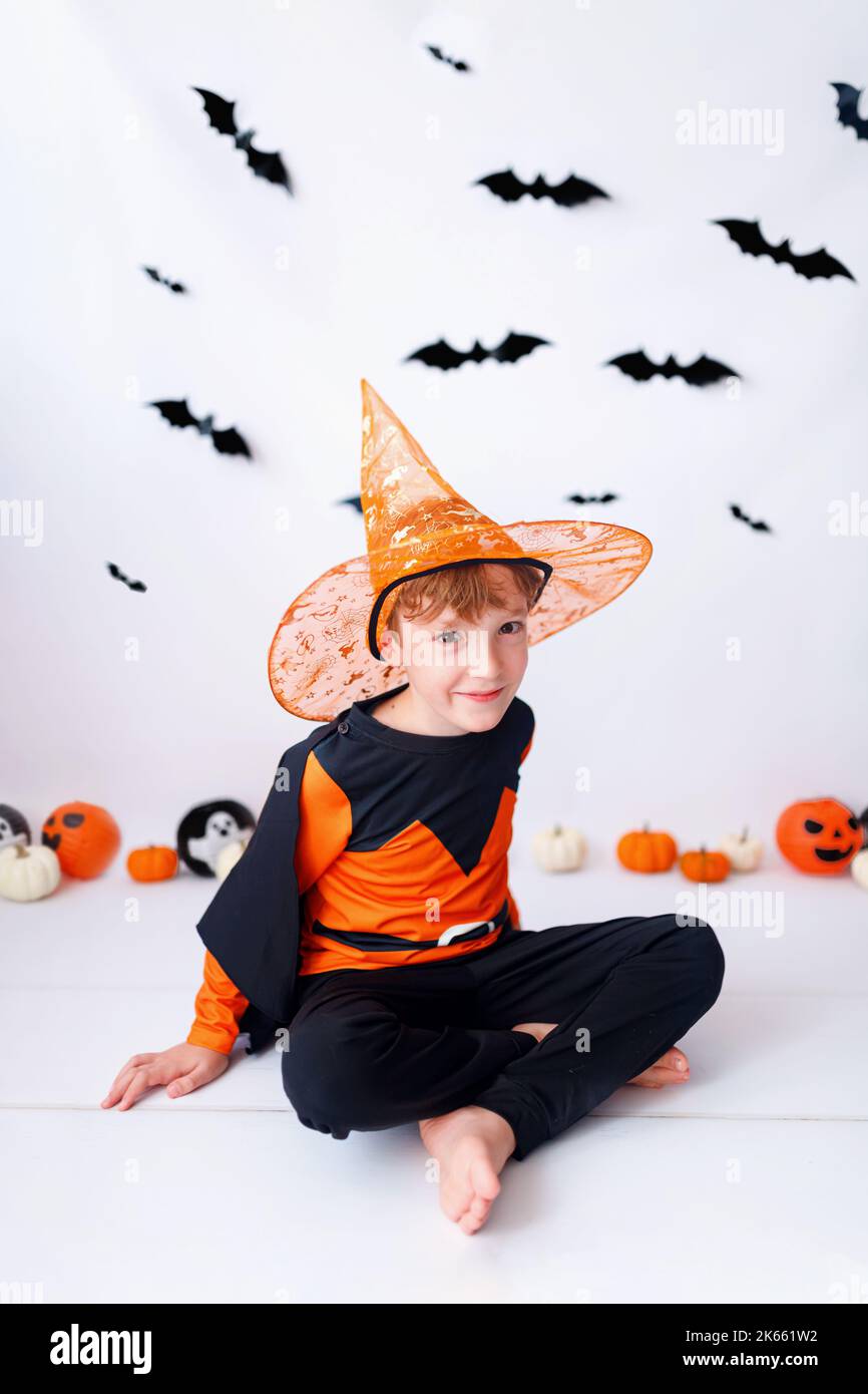 Felice sfondo di Halloween con zucca arancione e biondo ragazzo in costume di Halloween. Foto Stock