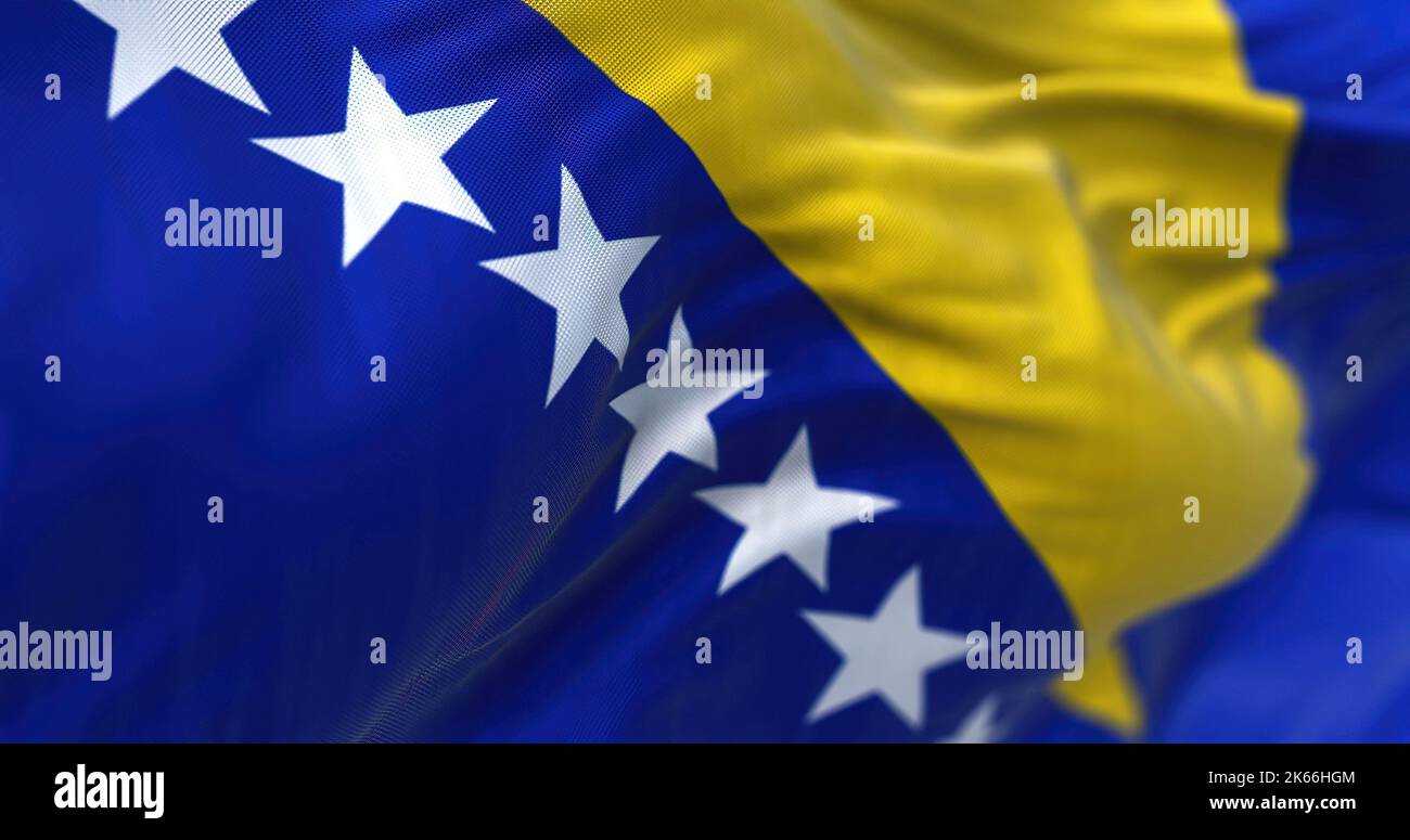 Vista ravvicinata della bandiera bosniaca che sventola nel vento. La Bosnia-Erzegovina è un paese che si trova al crocevia tra il sud e il sud-est dell'Europa. Fa Foto Stock