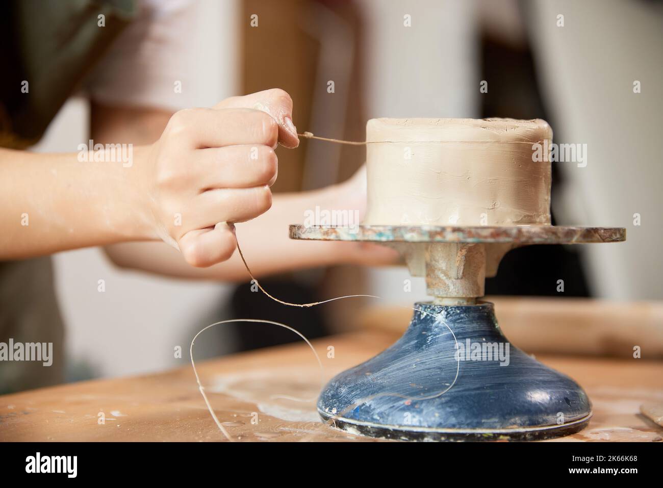 Mani di primo piano di ceramista femminile che lavora presso lo studio di ceramica su ruota di ceramica. Prodotti artigianali. Persone creative, hobby e abilità Foto Stock