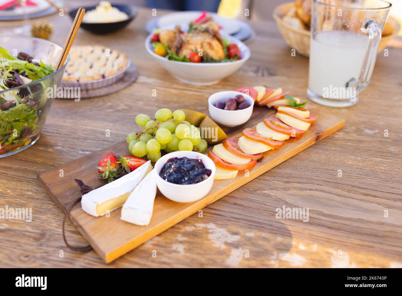 Un tavolo di legno preparato per un pasto nel giardino soleggiato Foto Stock