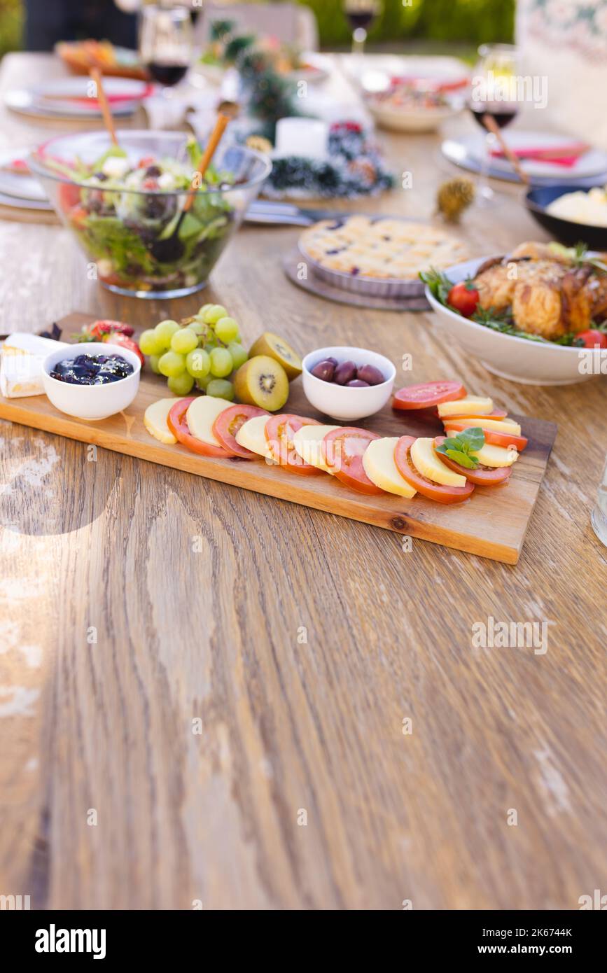 Immagine verticale di un tavolo di legno preparato per un pasto nel giardino soleggiato Foto Stock