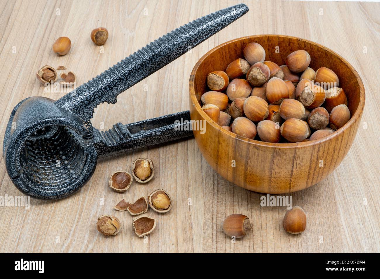 Nocciole in una ciotola con un rompigranella accanto ad esso sul tavolo Foto Stock