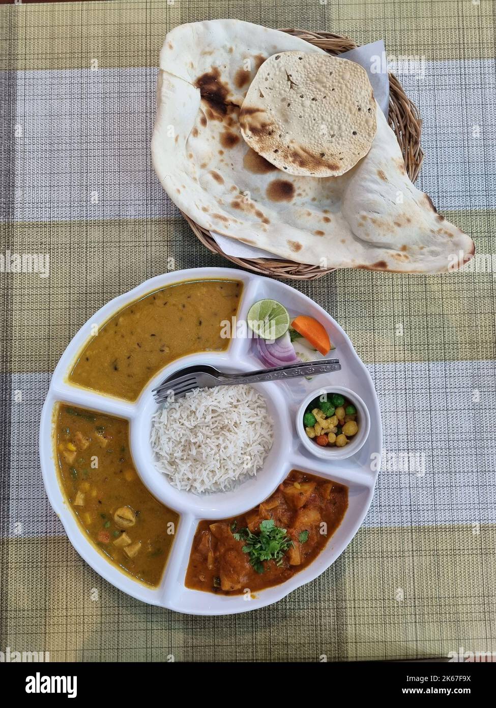 Delizioso pasto vegetariano indiano thali con riso e pane di roti Foto Stock
