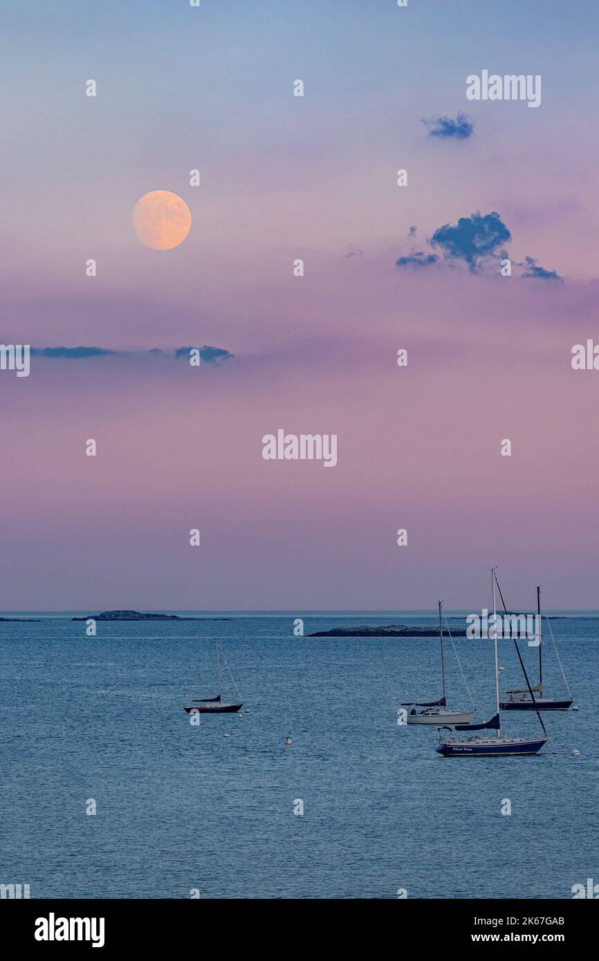 Luna dei Cacciatori illuminata al 96% con il vibrante cielo rosa e lavanda che sale sul canale Foto Stock