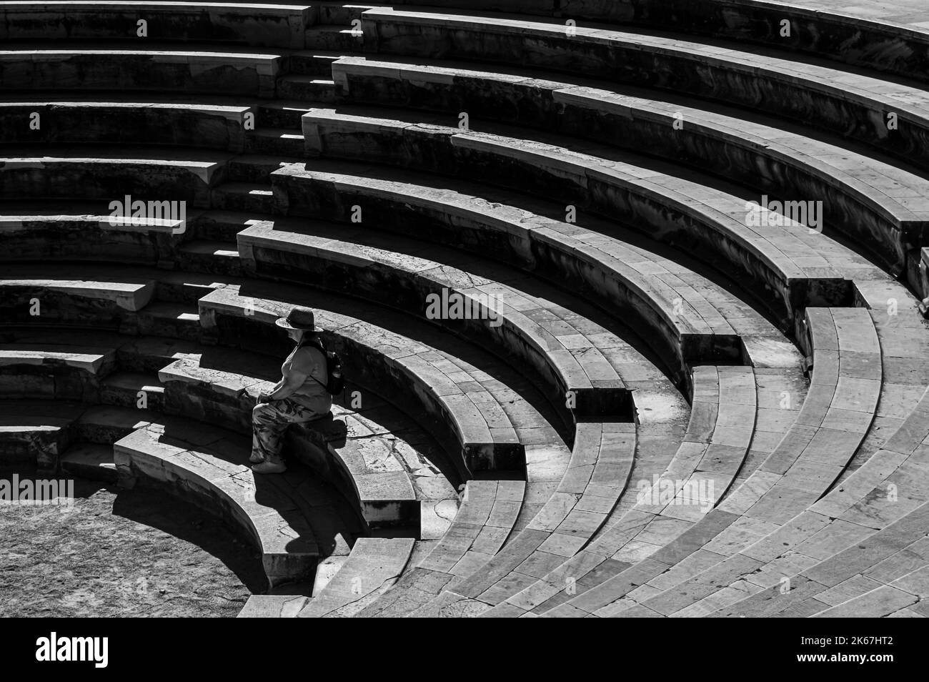 Immagine in bianco e nero di una donna con un cappello di paglia seduto in un odeon Foto Stock