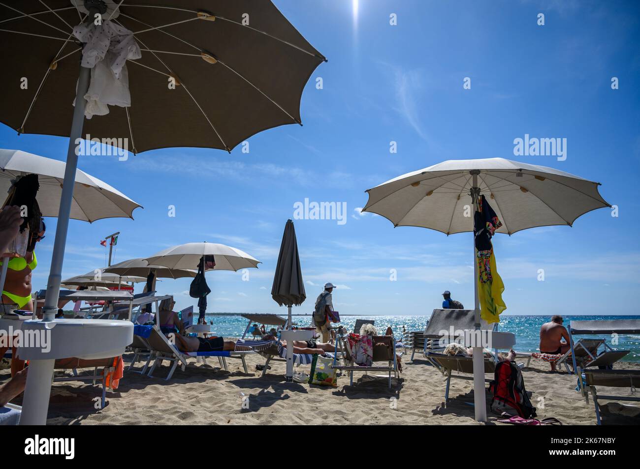 Bagnanti e beachgoer con lettini e ombrelloni sulla spiaggia di Sottovento a sud della città di Gallipoli, Puglia, Italia. Foto Stock