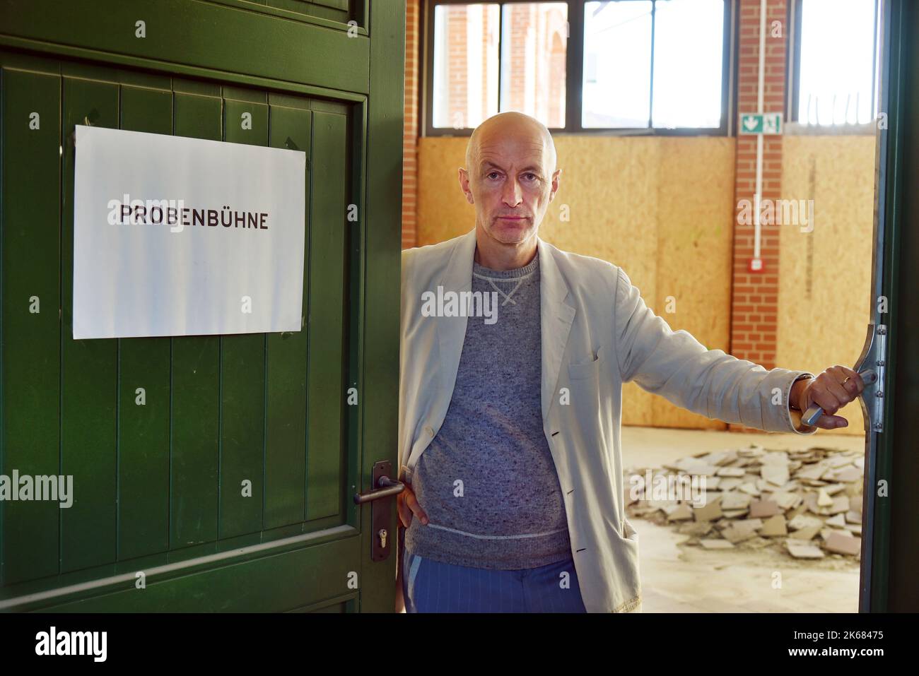 12 ottobre 2022, Sassonia-Anhalt, Naumburg: Stefan Neugebauer, direttore artistico del teatro più piccolo della Germania, si trova dietro una porta dove in futuro si terrà la prova, nell'ex macello della città. Il gioco dell'austriaco Th. Arzt si presenterà il 14 ottobre 2022. Il teatro, che ha uno staff di circa dodici persone, sarà dato una nuova casa nel vecchio mattatoio della città nella prossima stagione 2023/24. Invece di un buon 60 spettatori ora, gli edifici ristrutturati del 1930s avranno circa 100 posti a sedere. L'investimento di 3,5 milioni di euro proviene dallo stato sassone Foto Stock