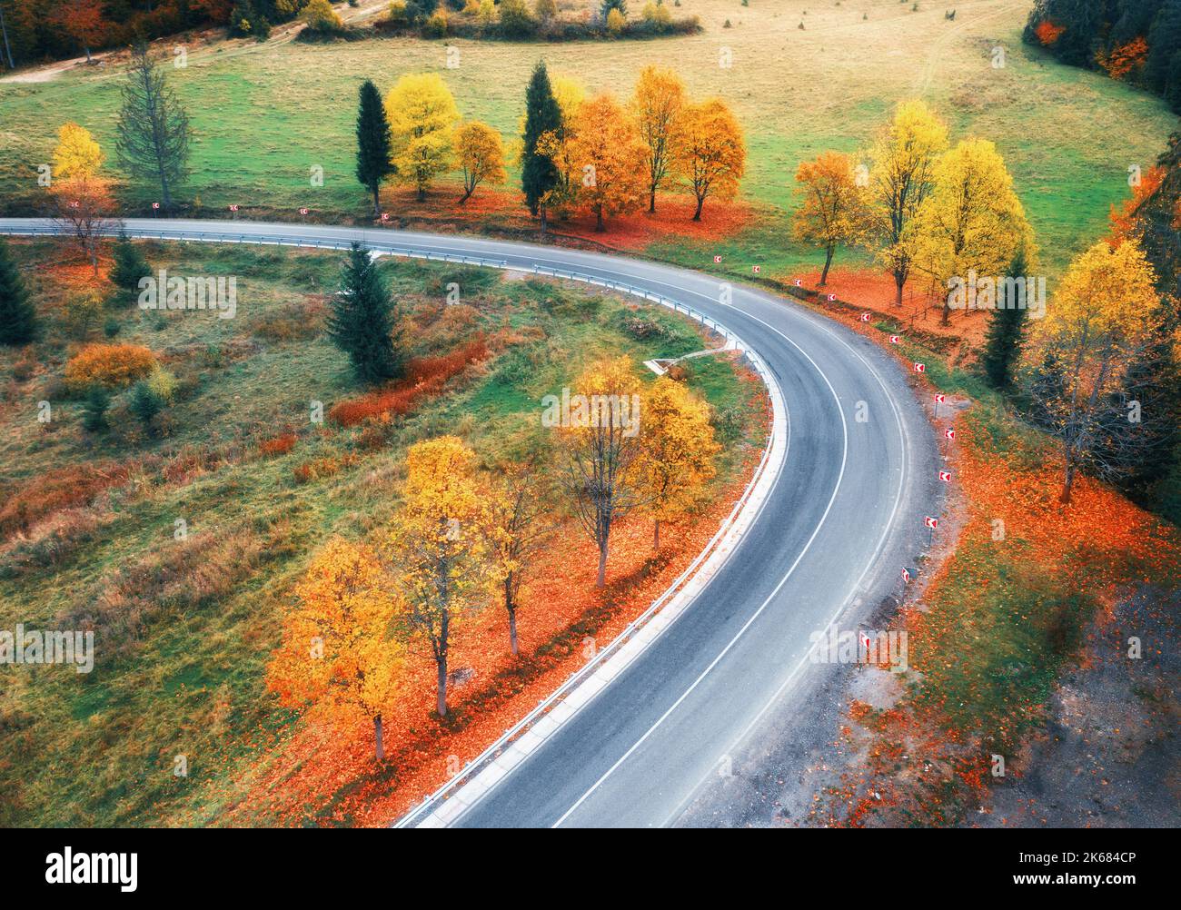 Vista aerea della strada tortuosa in autunno foresta al tramonto Foto Stock