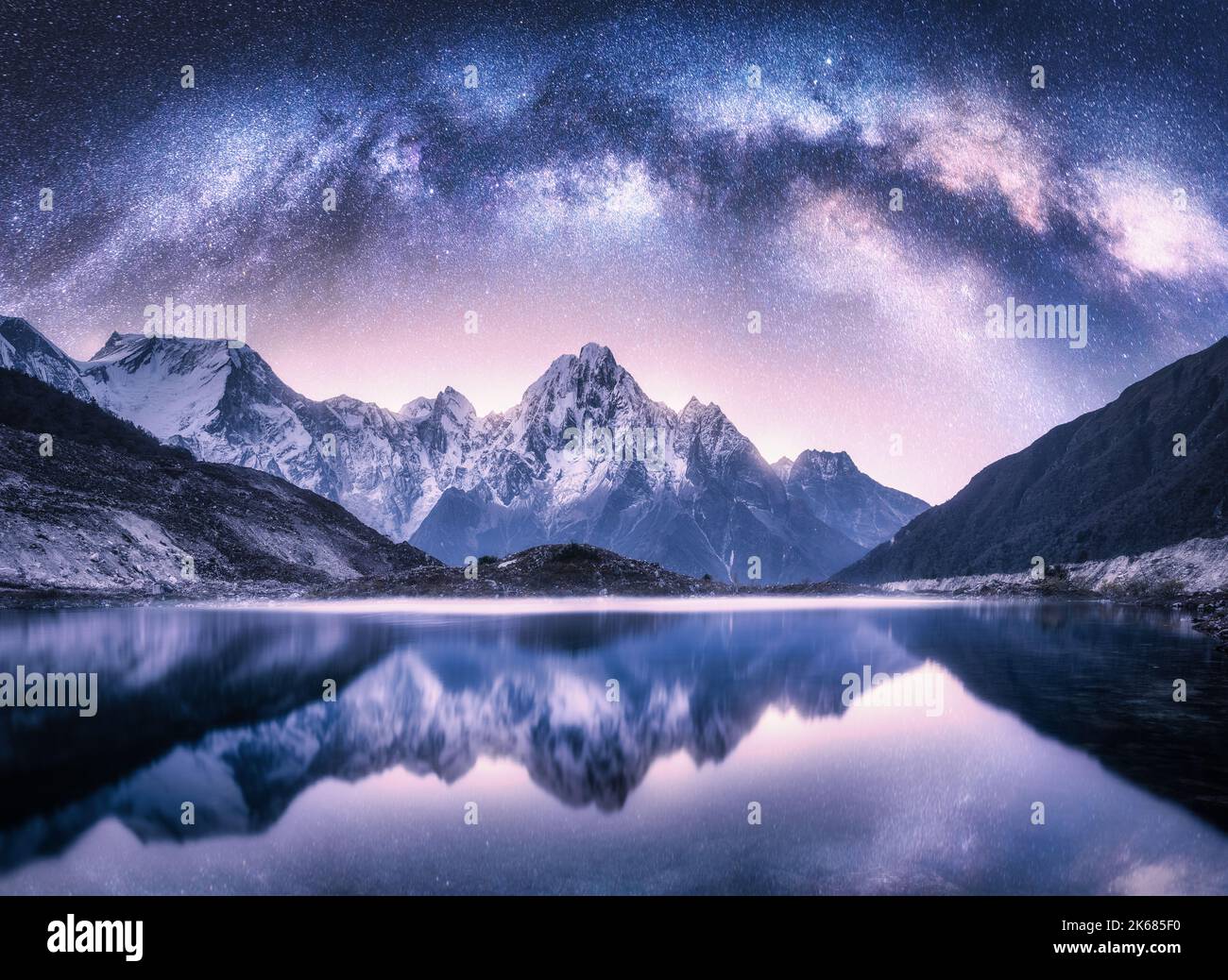 Arco di Via Lattea sulle montagne innevate e sul lago di notte Foto Stock