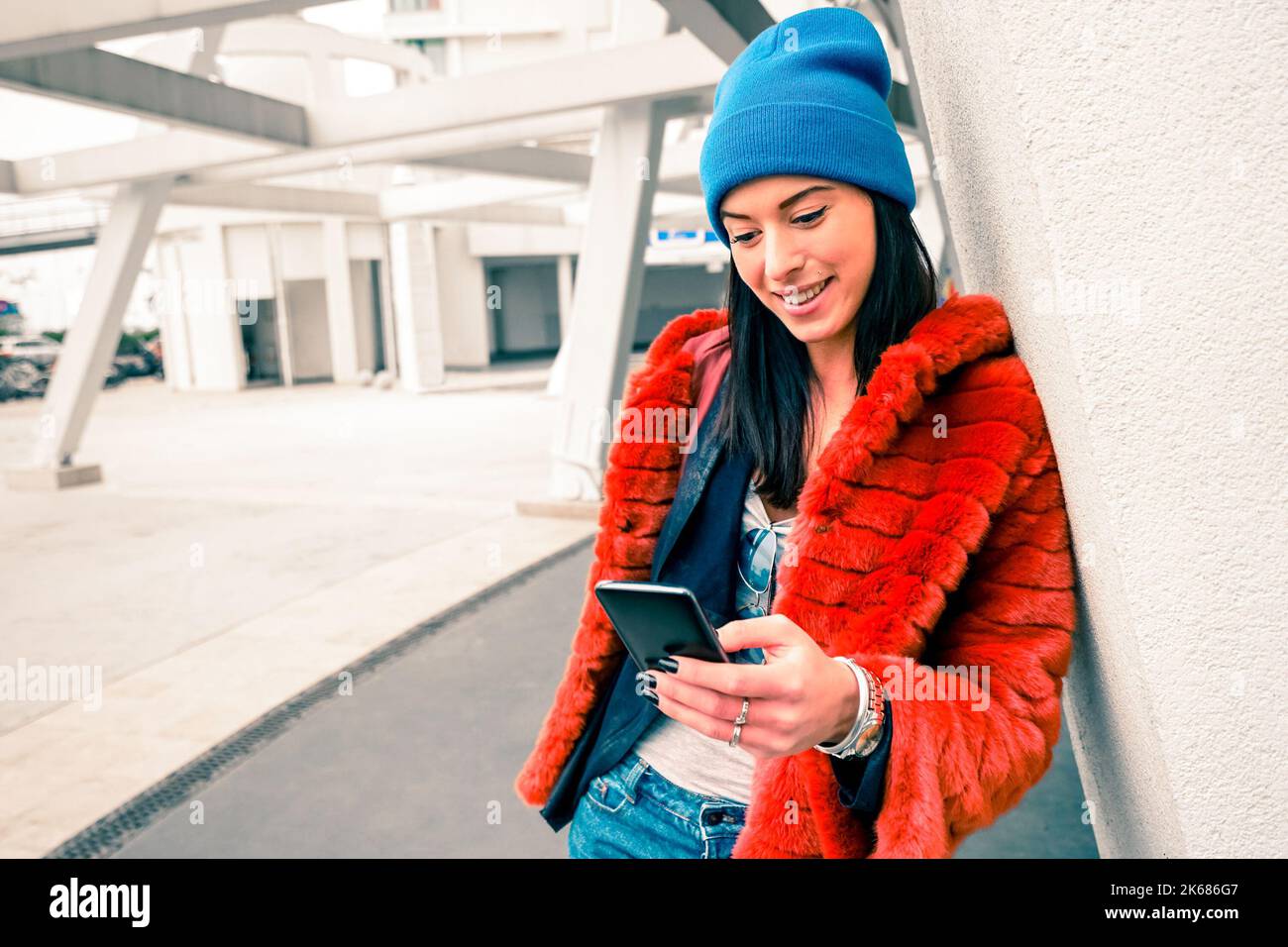 Ritratto di felice giovane donna con smartphone - ragazza hipster moda utilizzando smartphone cellulare in zona urbana - comunicazione stile di vita moderno e. Foto Stock