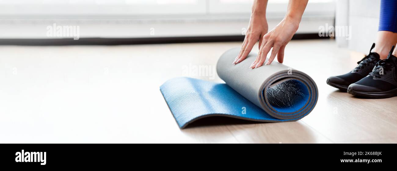 Donna pieghevole tappetino yoga, allenamento a casa concetto Foto Stock