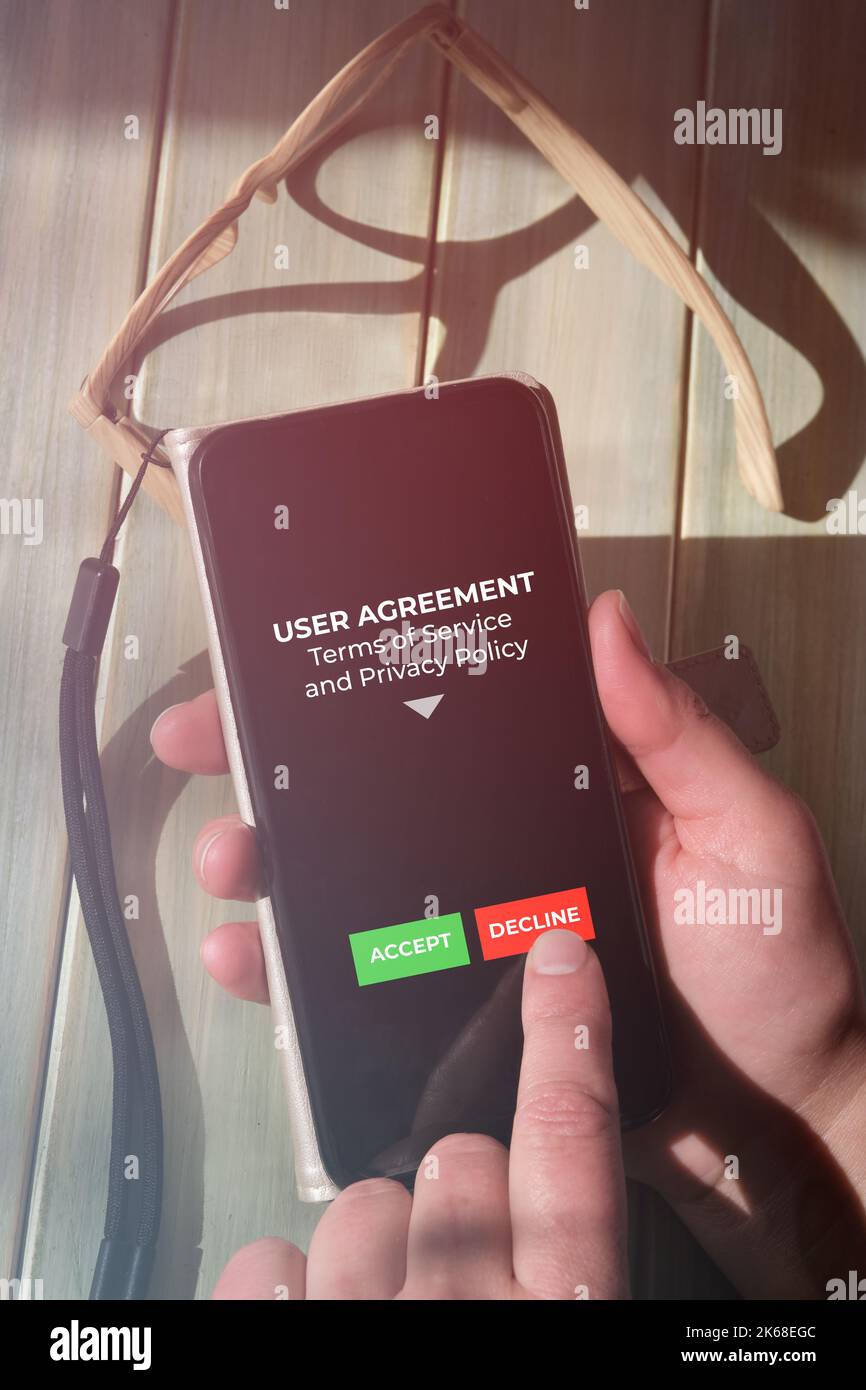 Premere con il dito il pulsante Rifiuta sullo schermo del telefono cellulare. L'utente non è d'accordo con le Condizioni d'uso e con l'app mobile Informativa sulla privacy. Primo piano sul dispositivo con Foto Stock